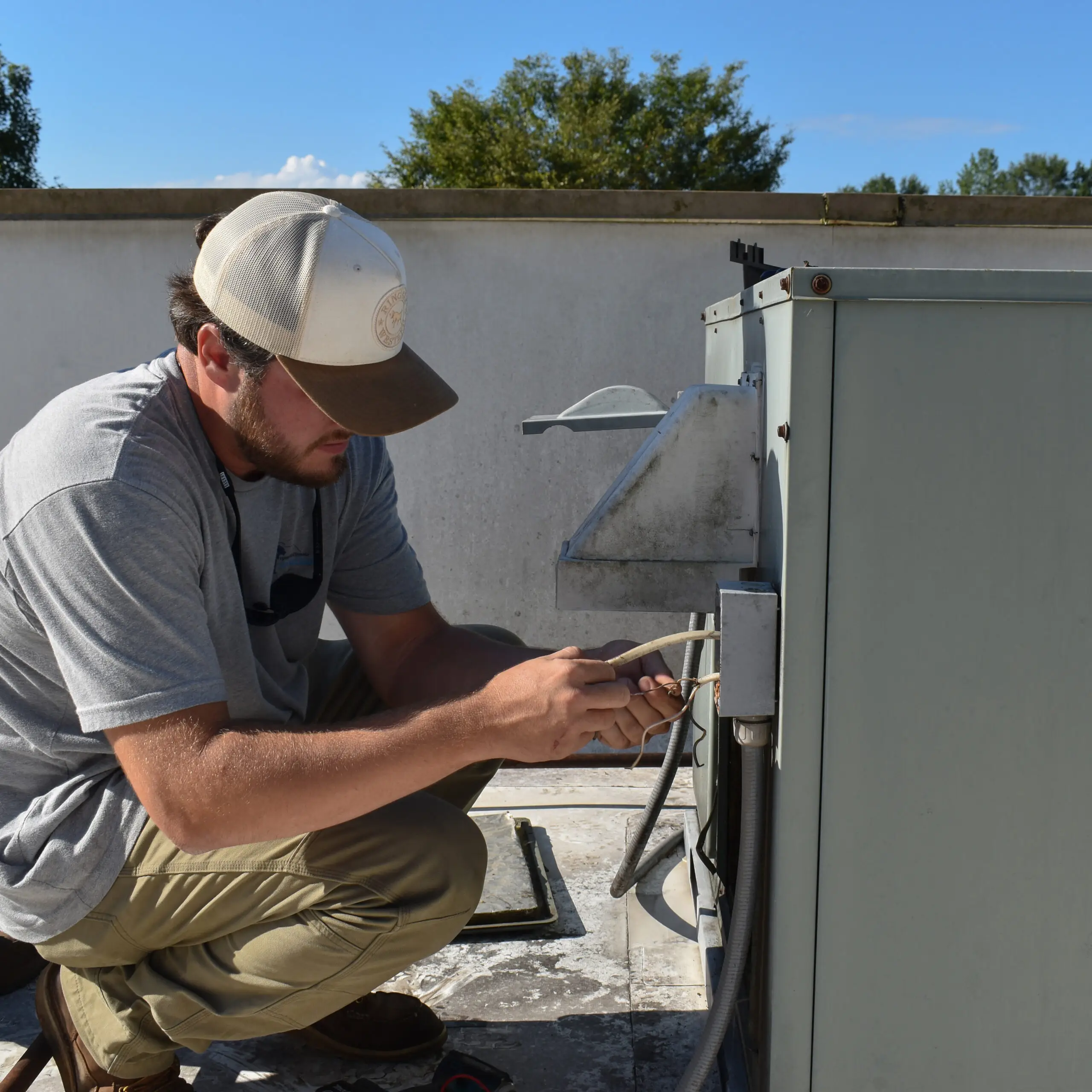 Employee working on an HVAC system's exposed wiring panel in Anderson, SC