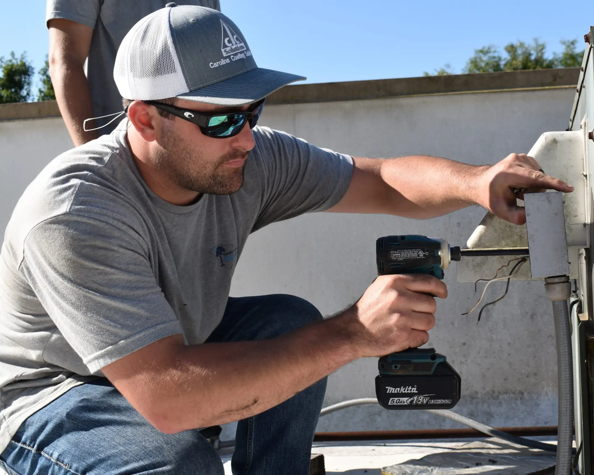 Upstate Climate Solutions employee working on HVAC system with a Makita screwdriver - 2