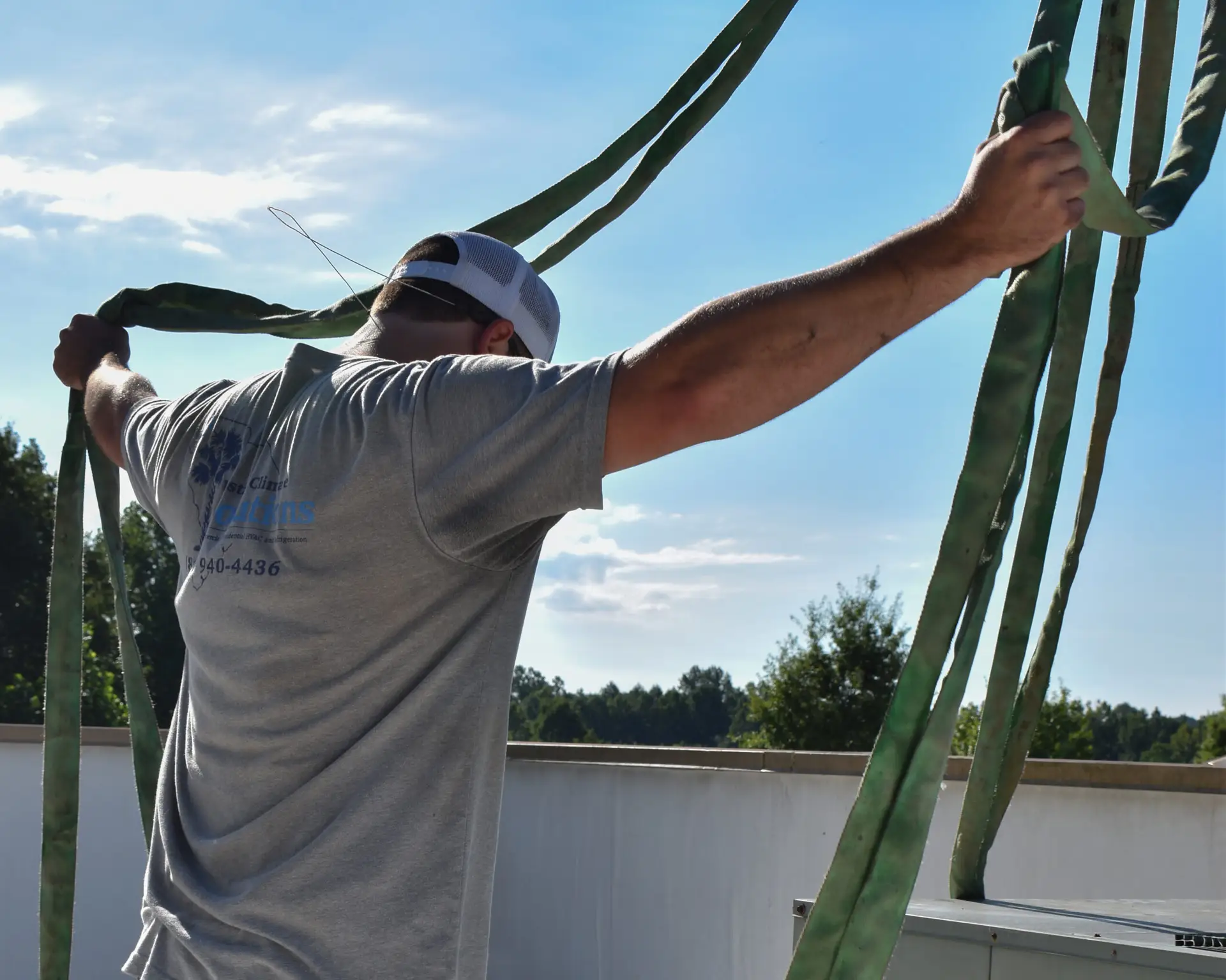 Upstate Climate Solutions Employee removing pulley system from residential HVAC system on roof