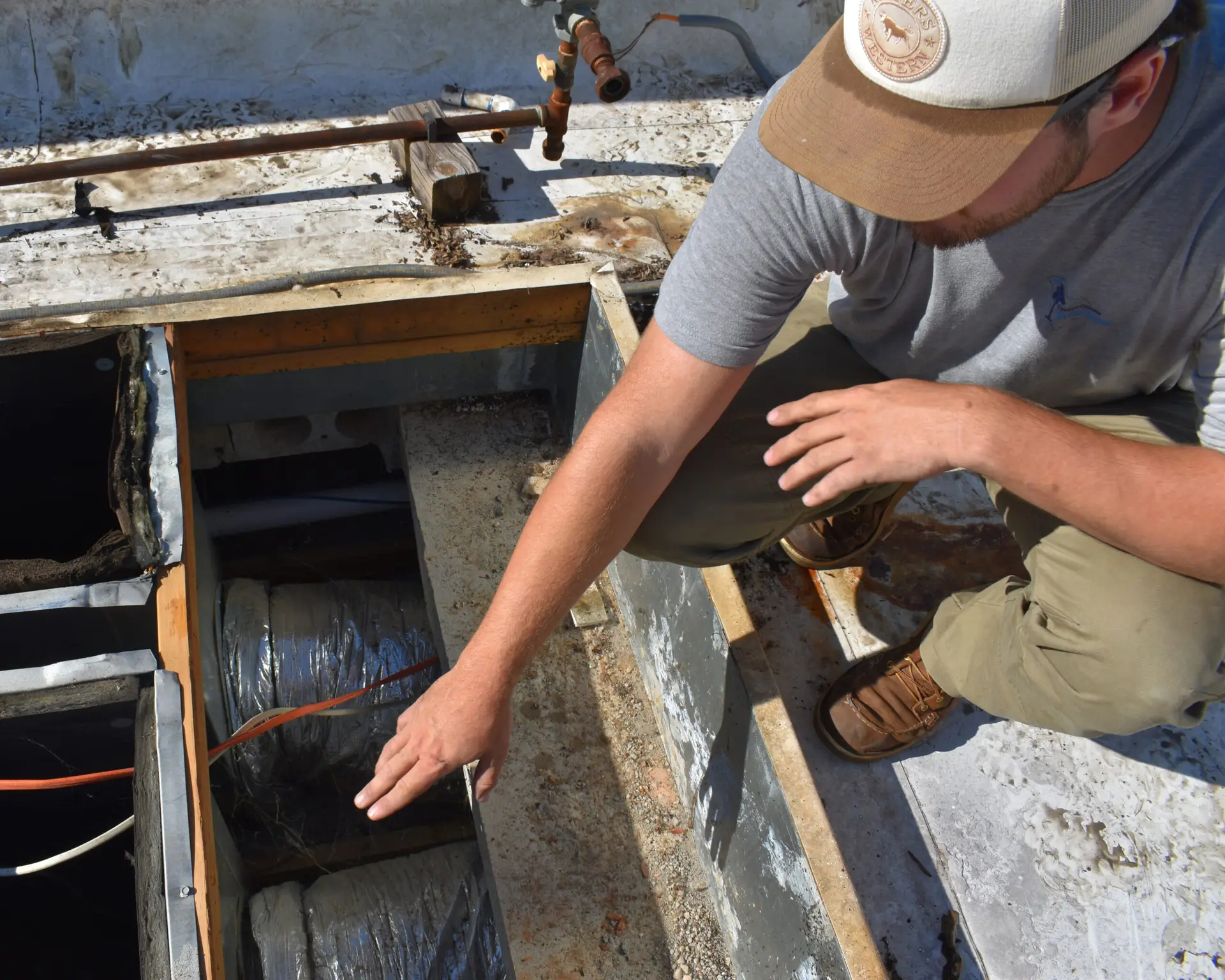 Worker from Upstate Climate solutions pointing at duct work