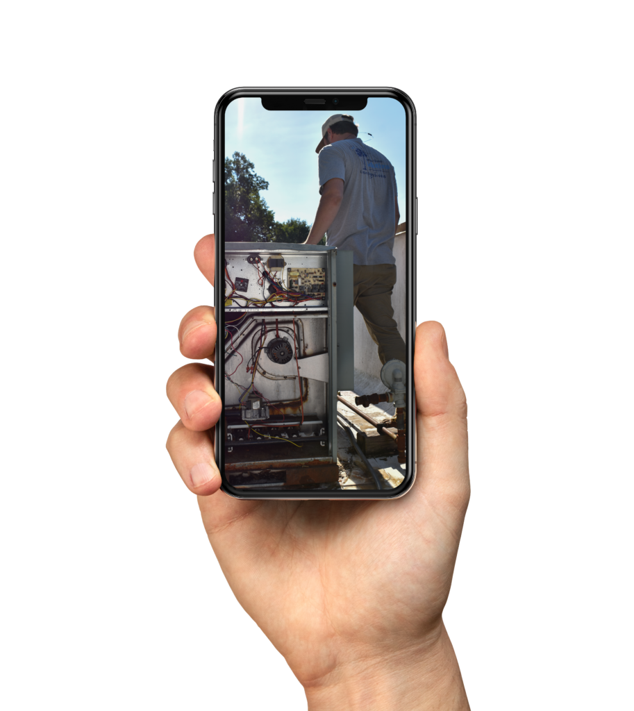 iPhone Mockup - hand holding an iPhone with a photo of Upstate Climate Solutions employee working on HVAC system