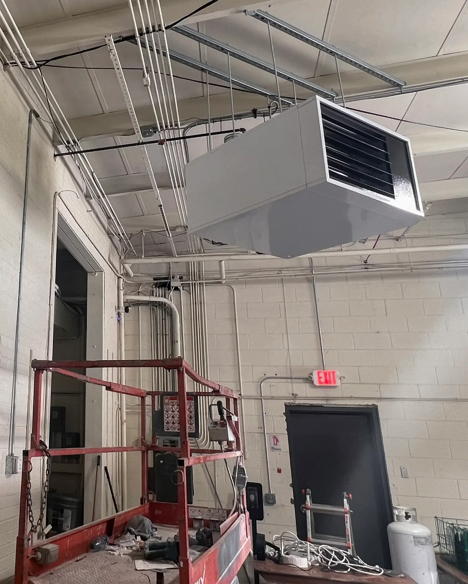 Commercial Heating and Cooling system hanging from the ceiling of an industrial building