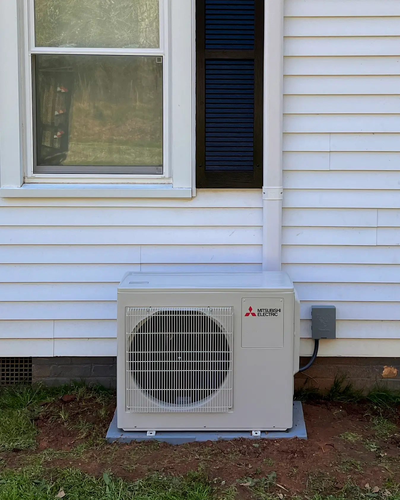 Mitsubishi mini-split heating and cooling unit - HVAC system - outside of residential home (close up)
